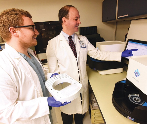 Dr. Eric Rosenbaum (right) and pathology resident Jonathon Gralewski, DO, in the University of Arkansas for Medical Sciences clinical microbiology lab with the Accelerate Pheno. All reactions and analyses are automated, Dr. Rosenbaum says, and bench experience is not needed to run the test 24 hours per day. Photo credit: Johnpaul Jones, UAMS